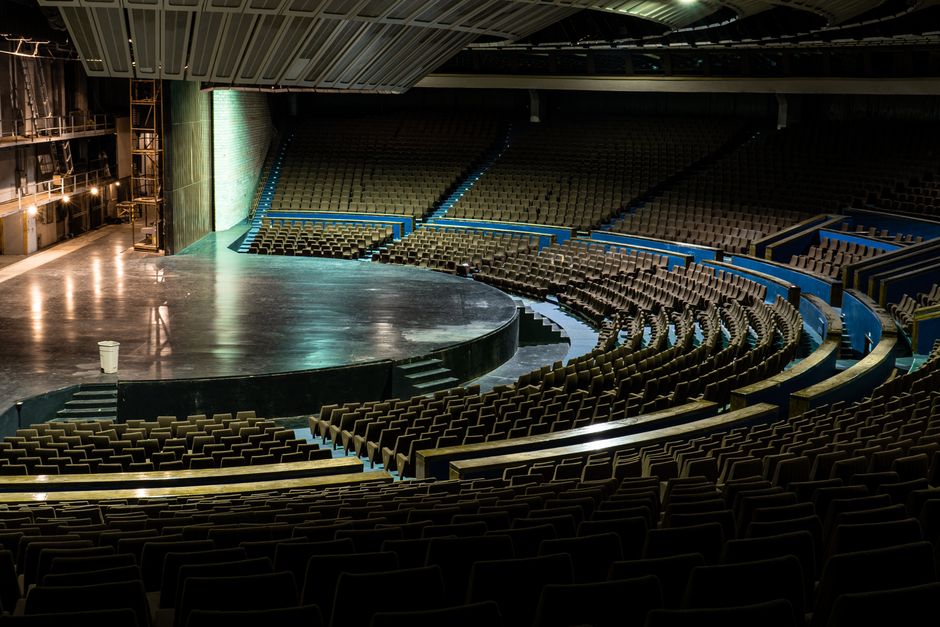 Softly lit empty theatre stage set for an evening of meditation and live music